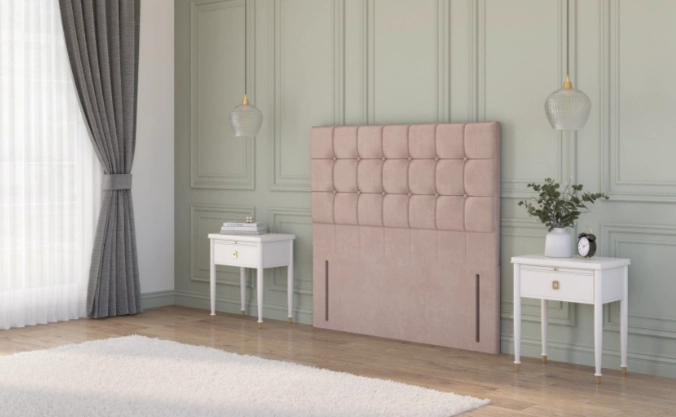 Chesterfield floor standing headboard in beige velvet, displayed between two black bedside tables in a classic interior.